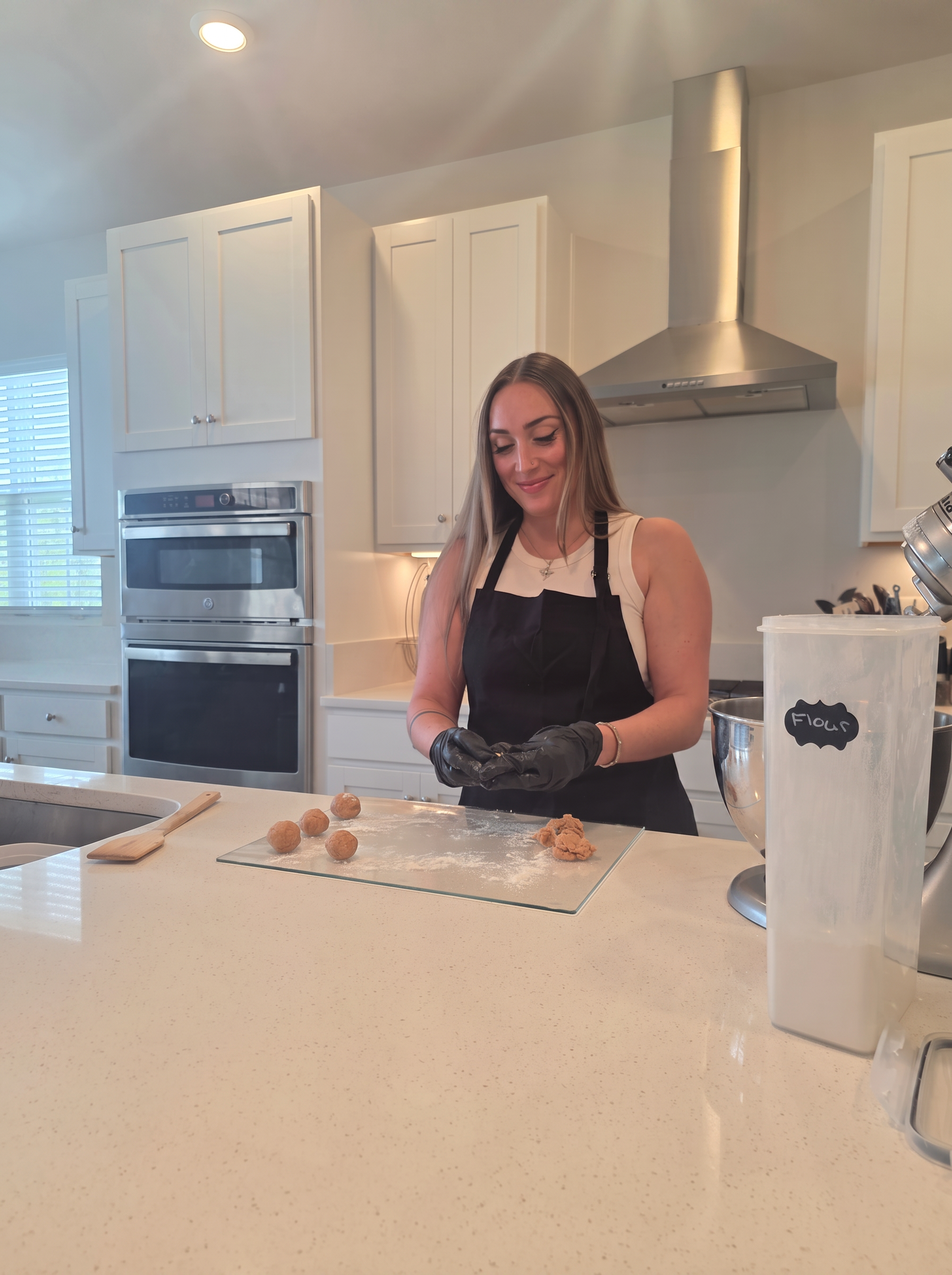 Claire shaping cookie dough on a floured board in her kitchen